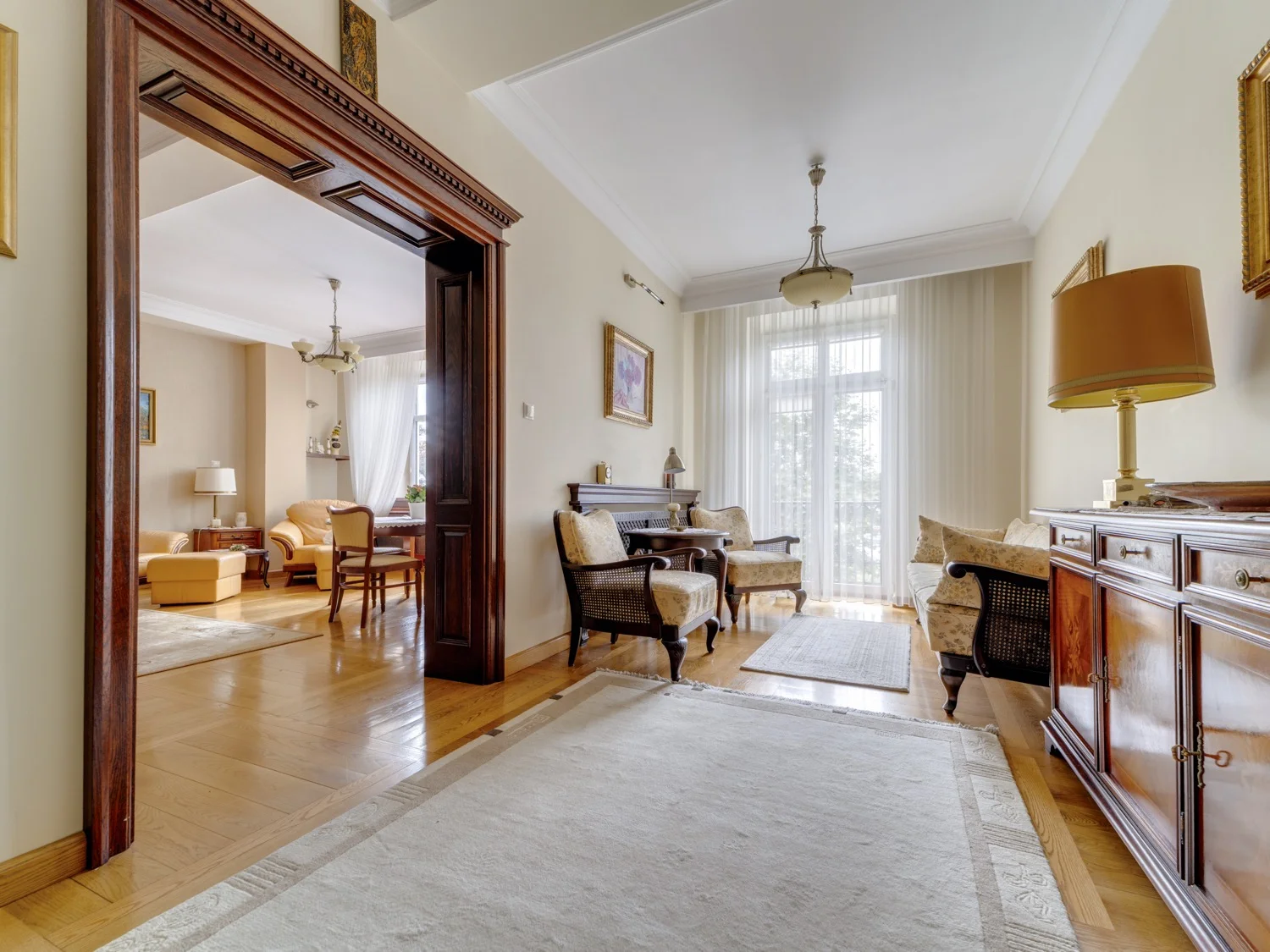 Wejście do salonu z widokiem na vintage meble i parkiet